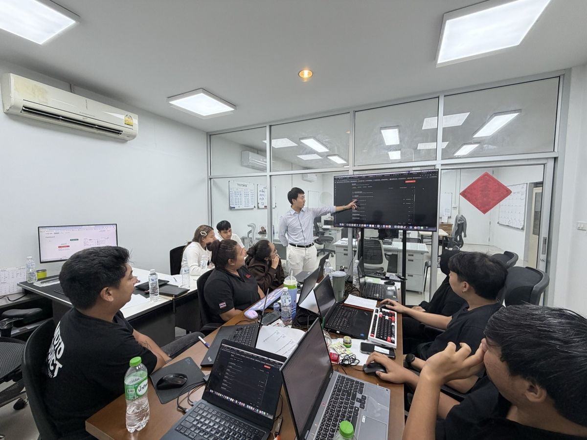 ปัน ณัฐพัชร์ ยืนอธิบายงานที่หน้าจอให้ทีมของลูกค้าฟัง
